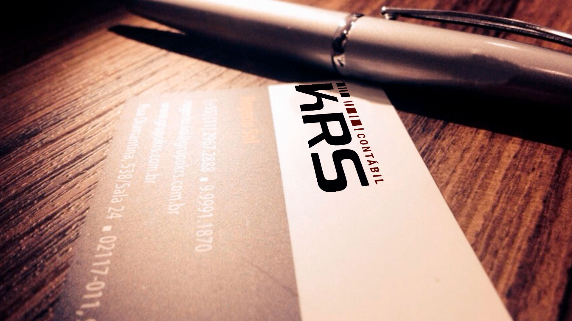 Cartão de visita e uma caneta com logo da KRS